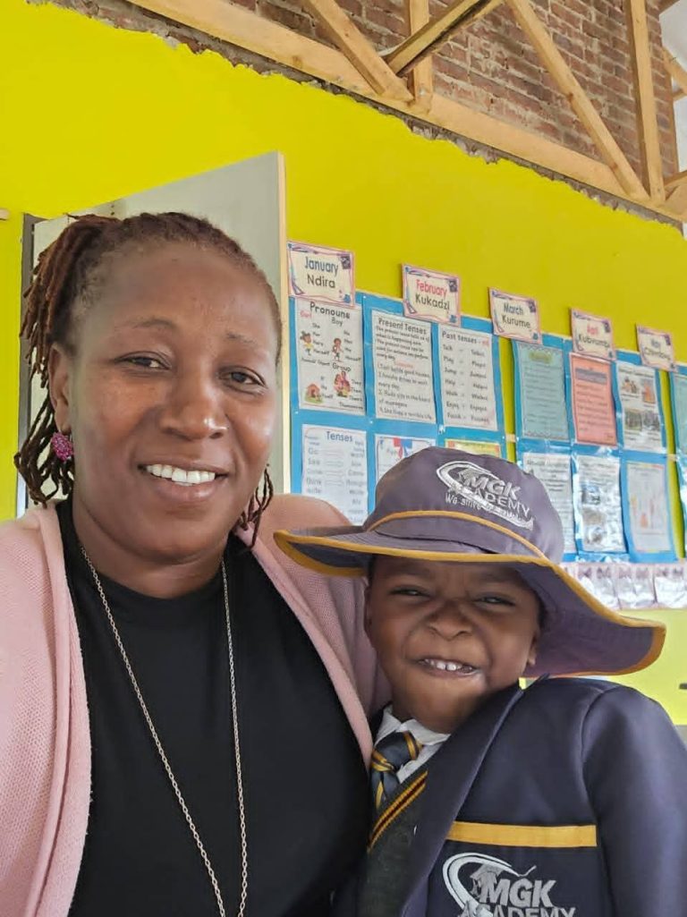Senior teacher smiling happily with a young student.